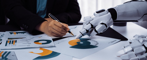 Robot hand helping human hand with business